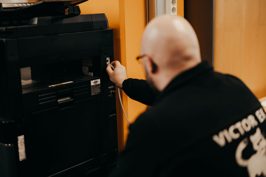 IT-palvelut muuton aikana, Victor Ekin työntekijä kytkee laitteet pois ja asentaa ne uudelleen paikoilleen uudessa kohteessa.
